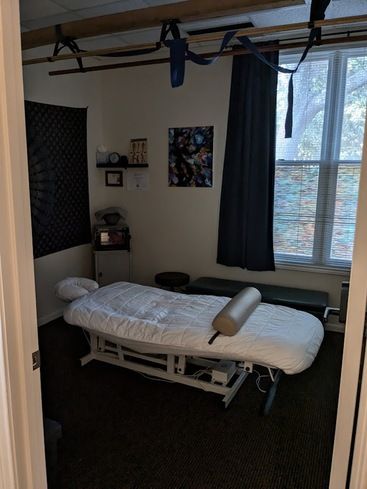 Private massage suite with treatment table and window light